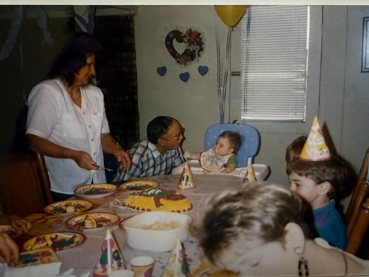 A child's birthday party with cake and party hats, from a digitized print